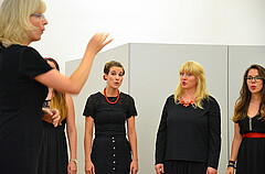 Das Bild zeigt Mitglieder des 4x4-Frauenchors beim Singen. Dabei werden sie von Heike Kiefner-Jesatko angeleitet.