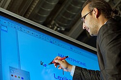 Das Bild zeigt einen Mann, der auf eine digitale Tafel schreibt. Copyright Pädagogische Hochschule Heidelberg