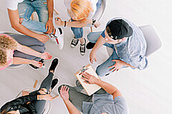 Das Symbolbild zeigt eine Gruppe von Menschen, die in einem Stuhlkreis sitzen. Das Bild wurde von oben aufgenommen, sodass man keine Gesichter erkennt. Copyright Pädagogische Hochschule Heidelberg