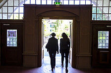 Two persons leaving the Heidelberg University of Education through the main door