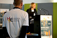 Das Bild zeigt einen Mann von hinten. Auf seinem T-Shirt ist das Logo der Heidelberg School of Education (HSE) abgebildet.