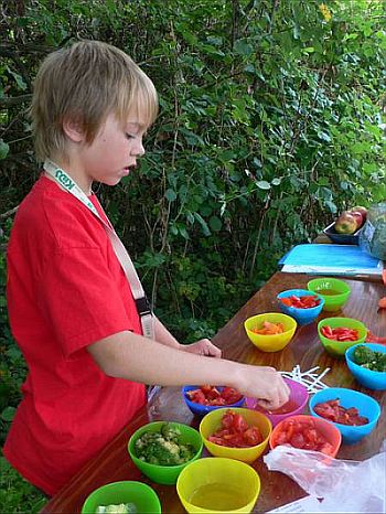Kind prüft den Vitamingehalt von Gemüse und Obst im Garten