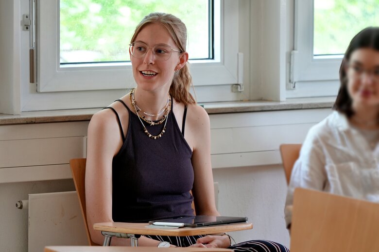 Eine Studentin sitzt an einem Tisch im Seminarraum.
