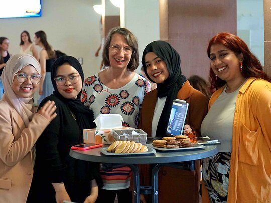 [Übersetzen nach: English] Die Leitung des Akademischen Auslandsamts steht mit internationalen Studierenden im Altbau der Pädagogischen Hochschule Heidelberg.