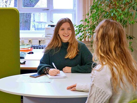Zwei Frauen im SSC während einer Beratung zum Lehramtsstudium an der PHHD. Sie sitzen an einem runden Tisch.