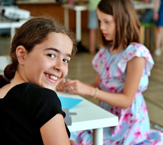 Zu sehen sind zwei Schülerinnen im Klassenzimmer.