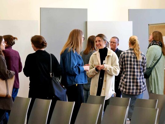 Gruppe an Frauen stehen zusammen und unterhalten sich über PHÖNIX.