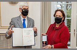 Das Bild zeigt Professor Gert Weisskirchen (links) und daneben Staatsministerin Theresa Schopper (rechts) beim Überreichen des Bundesverdienstkreuzes. Copyright Staatsministerium Baden-Württemberg