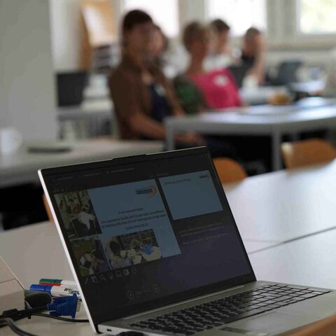 Zu sehen ist ein aufgeklappter Laptop während eines Forschungskolloquium. 