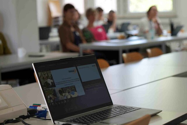Zu sehen ist ein aufgeklappter Laptop während eines Forschungskolloquium. 