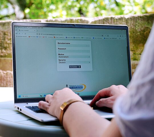 Eine Person tippt am Laptop. Auf diesem sieht man das Mailprogramm Horde der Pädagogischen Hochschule Heidelberg.