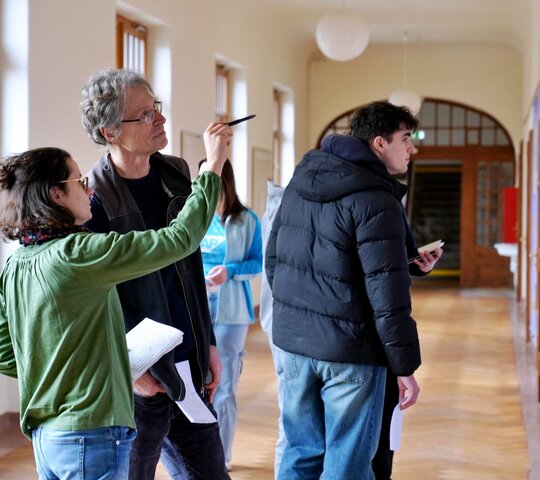 Zu sehen sind drei Menschen beim Holocaust-Gedenktag an der PH Heidelberg.
