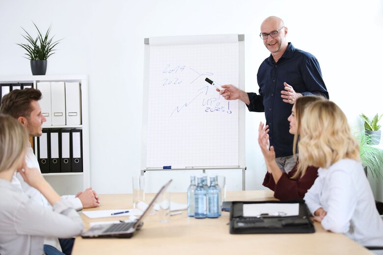 Personen sitzen im Büro und unterhalten sich.