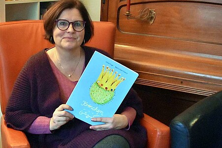 Die Autorin Ulrike Finger hält ihr eigenes Bilderbuch "Krönchen" in den Händen