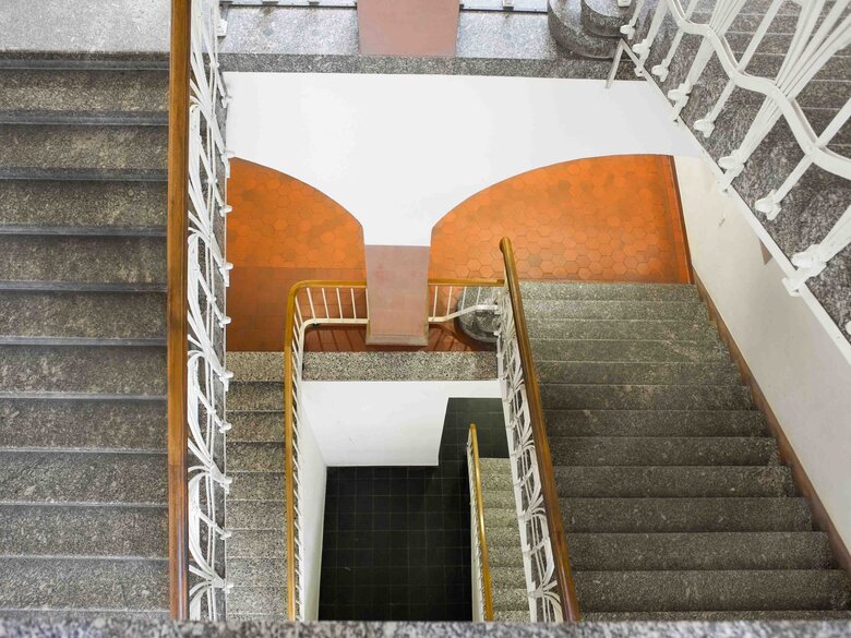 Das Bild zeigt Treppenstufen  im Altbau der PH-Heidelberg, die nach unten führen