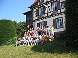 Menschen posieren in Gras vor Haus