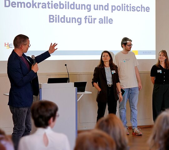 Zu sehen ist eine Präsentation mehrerer Personen. 