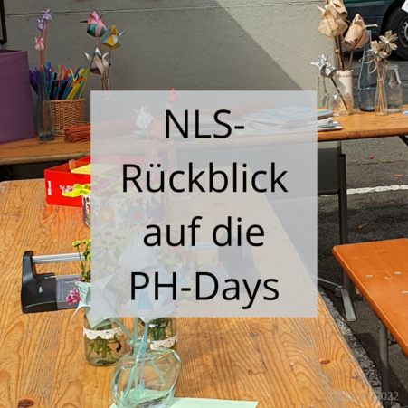 Detailansicht eines Tisches mit selbstgebastelten Papierblumen, davor die Überschrift 'NLS-Rückblick auf die PH-Days'