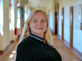 Porträtaufnahme von Daniela Sperling auf dem Flur des Altbaus der PH Heidelberg