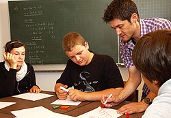 Lehrer der seinem Schüler hilft.