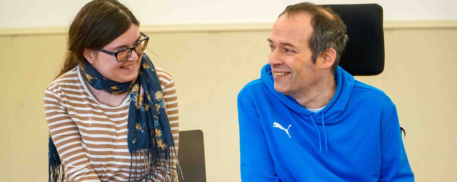 Das Bild zeigt die Bildungsfachkräfte Anna Neff und Thorsten Lihl. Sie lächeln sich an.