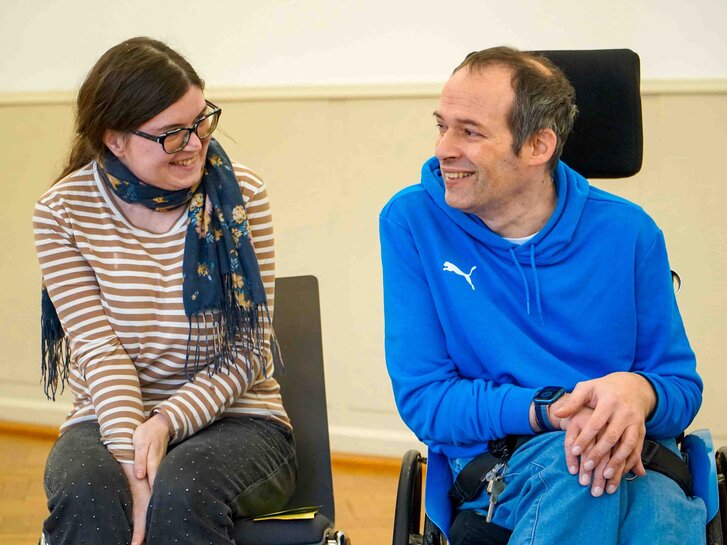 Das Bild zeigt die Bildungsfachkräfte Anna Neff und Thorsten Lihl. Sie lächeln sich an.