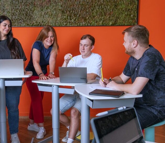 Studierendenwerk Heidelberg - Studierende sitzen auf einer Bank.