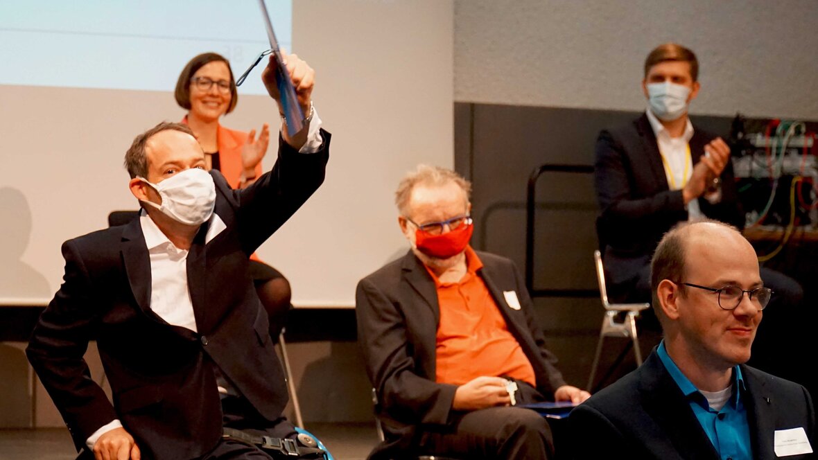 Thorsten Lihl hält seinen Arbeitsvertrag in die Höhe.