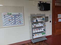 Abgebildet ist die Pinnwand mit dem Buchungskalender im Flur des PH-Altbaus. Rechts neben dem Plakat ist die Eingangstüre des Student Service Centre.