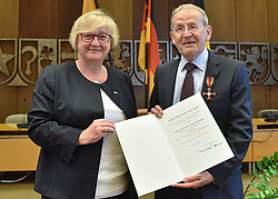 Auf dem Bild sieht man Prof. Dr. Joachim Maier und eine Frau die zusammen ein Schriftstück in den Händen halten.
