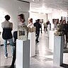 Das Bild zeigt eine Vielzahl an Personen auf einer Kunstausstellung im Kunstfoyer der Pädagogischen Hochschule Heidelberg.