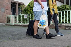 Das Symbolbild zeigt zwei Studierende mit Koffern und Taschen, die das Hochschulgelände der Pädagogischen Hochschule verlassen. Copyright Pädagogische Hochschule