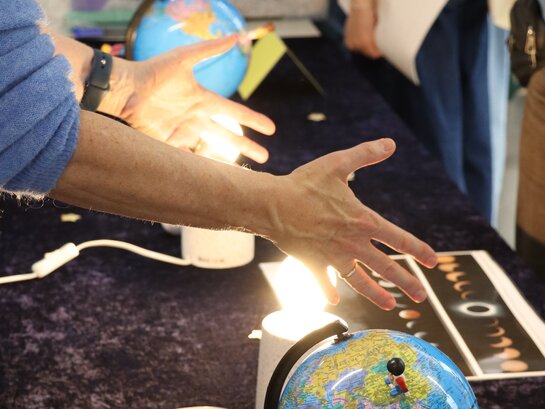 Das Foto zeigt einen Tisch mit Materialien zum Thema Astronomie.