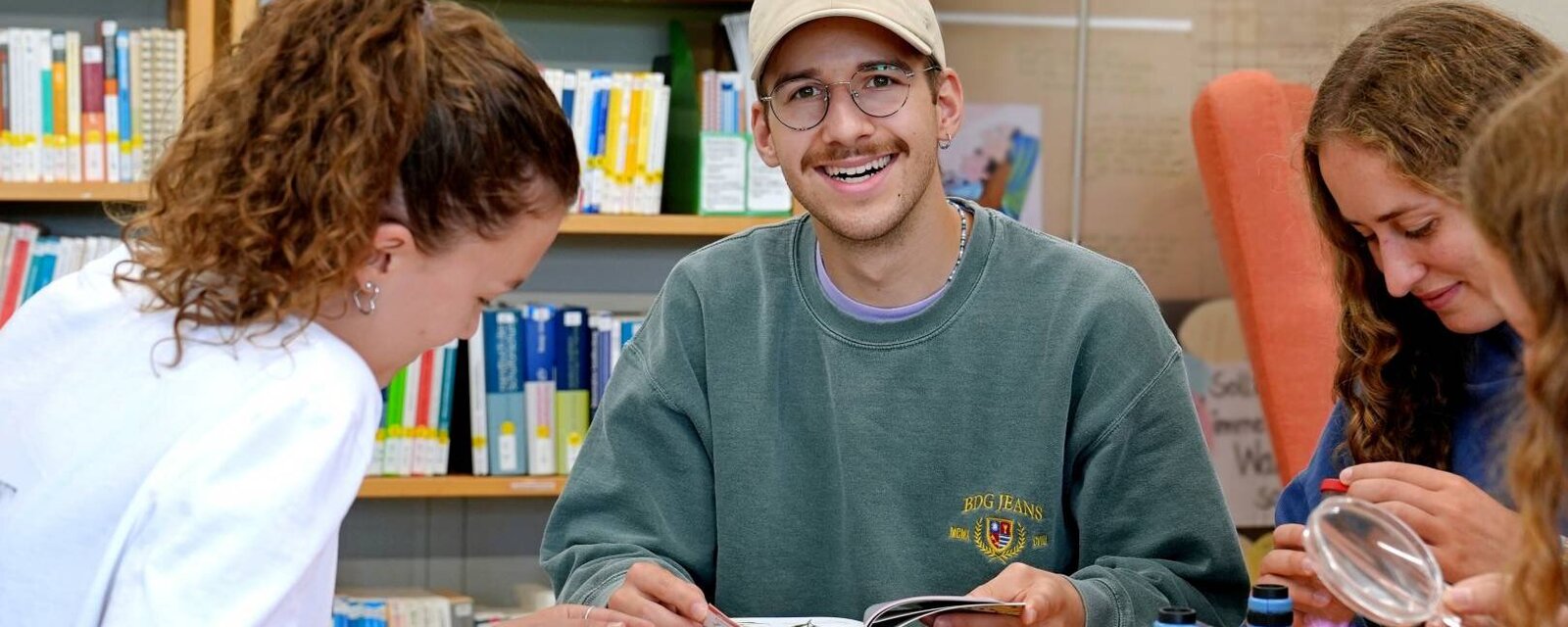 Zu sehen ist ein Student, der in die Kamera lächelt.