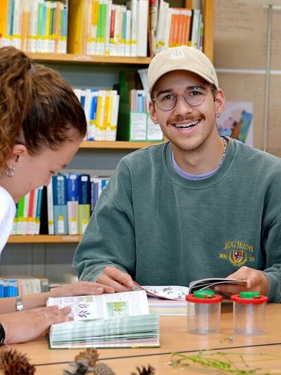 Zu sehen ist ein Student, der in die Kamera lächelt.