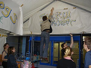 Mann hängt Schriftzug auf