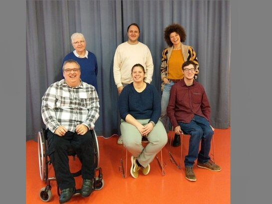 Das Foto zeigt sechs Menschen, welche in die Kamera lächeln.