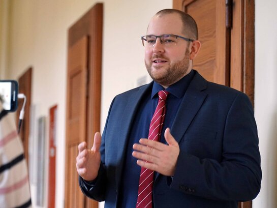 Prof. Dr. David Scheer wird auf dem Flur des Altbaus der PH Heidelberg interviewt.