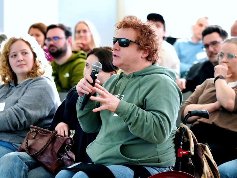Das Foto zeigt einen Besucher der Fachtagung Extremismus und Radikalisierung, der gerade eine Frage stellt.