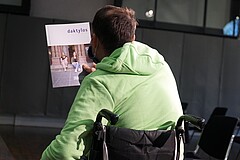 Auf dem Bild ist ein rollstuhlfahrer von hinten zu sehen, der das aktuelle daktylos-Heft in der Hand hält. Copright: Pädagogische Hochschule Heidelberg