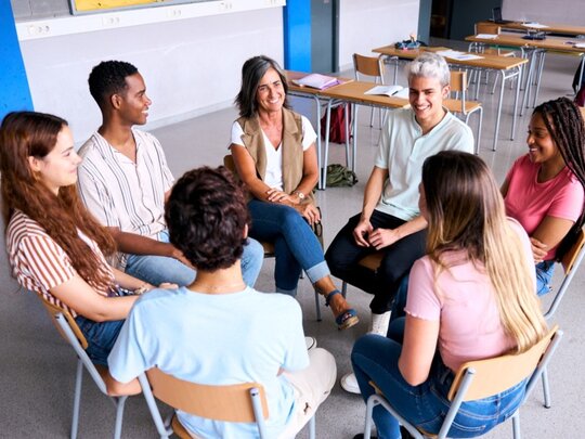 Gruppengespräch mit Menschen, die in einem Stuhlkreis sitzen.