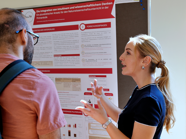 Tagungsgäste der "Gesellschaft für Didaktik der Chemie und Physik" diskutieren vor einem Poster