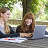 Das Symbolbild zeigt zwei Studierende, die im Innenhof der alten PH sitzen und auf einen Laptop schauen. Copyright: PH Heidelberg