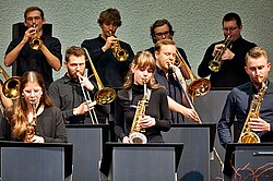 Das Foto zeigt einen Teil der Jazz-BigBand. Es sind Instrumente, wie Saxophon und Trompete erkennbar.