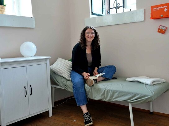 Eine Studierende ruht sich im Ruheraum aus.