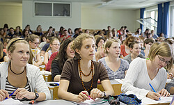 Studierende an Tischen im Hörsaal.