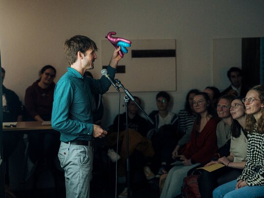 Valentin Kleinpeter steht beim Science Slam auf der Bühne und spricht über sexuelle Bildung.