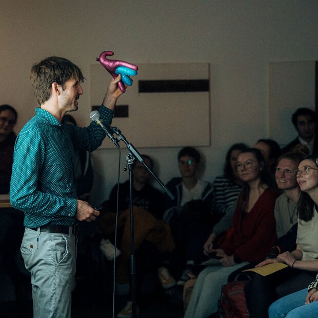 Valentin Kleinpeter steht beim Science Slam auf der Bühne und spricht über sexuelle Bildung.