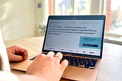 Man sieht primär einen Laptop. Auf diesem ist die Website digiatschool4all.de zu sehen.