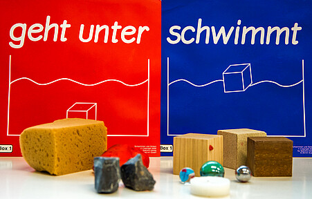 Auswahl an Materialien aus der KiNT-Box zum Thema "Schwimmen und Sinken"